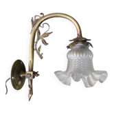 Antique brass wall light with glass shade.