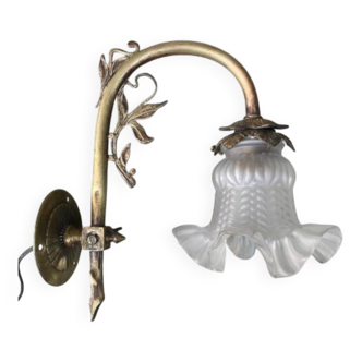 Antique brass wall light with glass shade.