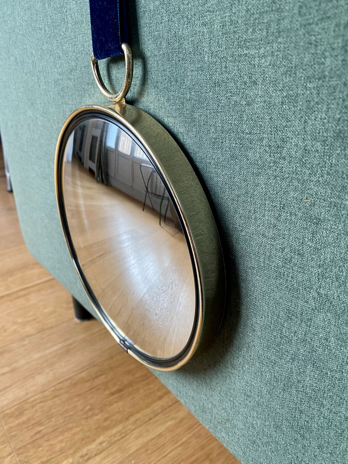 Vintage witch's eye curved mirror hangs velvet ribbon