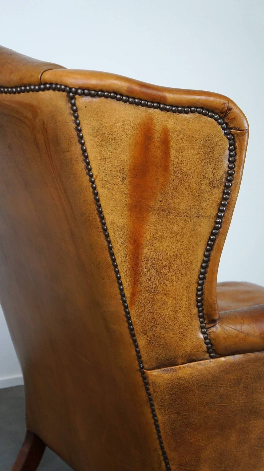 Positively lived-in sheepskin leather wing chair with pleasant seating comfort
