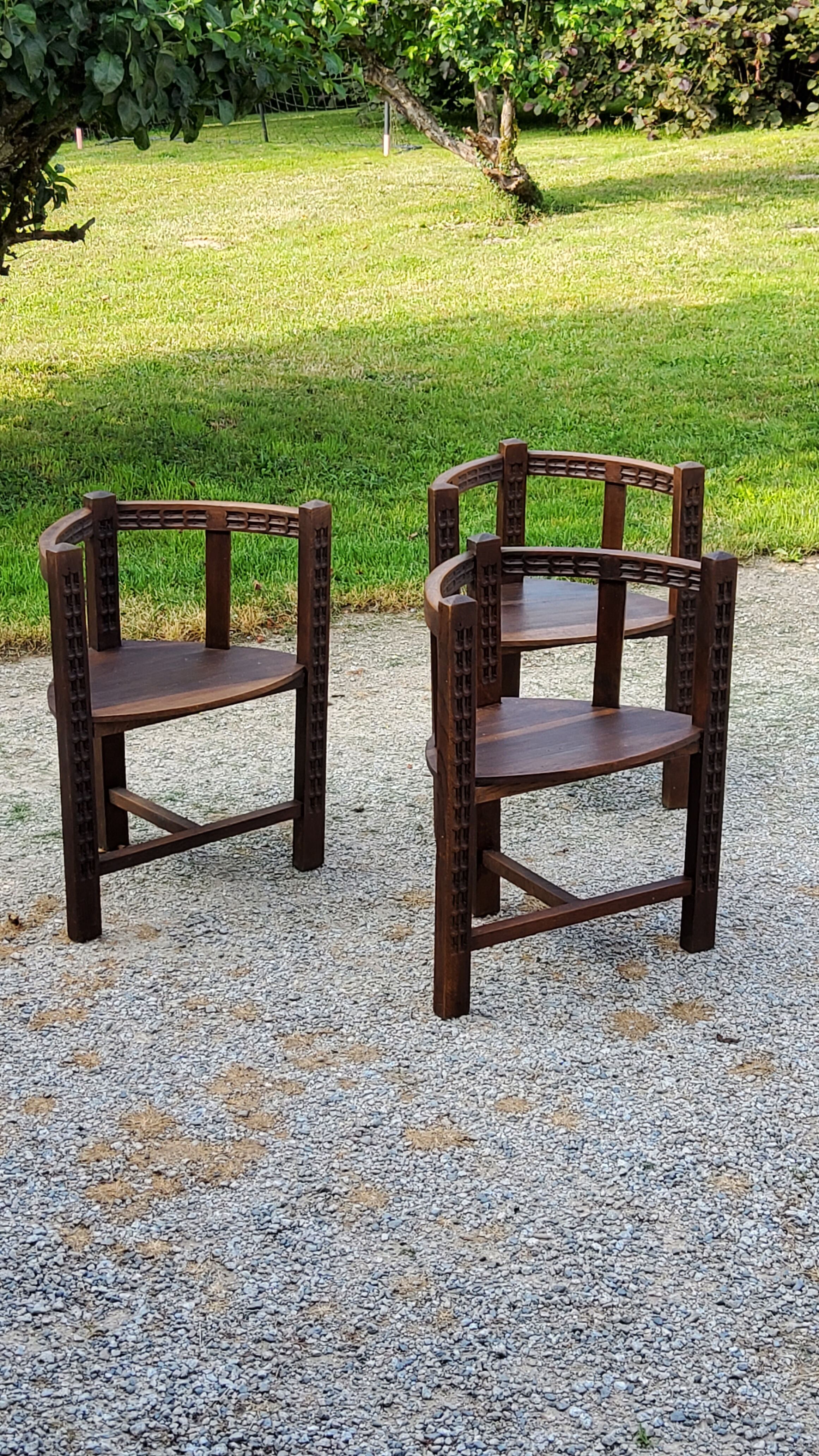 Set of three brutalist tripod armchairs in carved solid oak