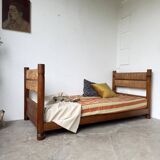 Brutalist style bed with chain and straw