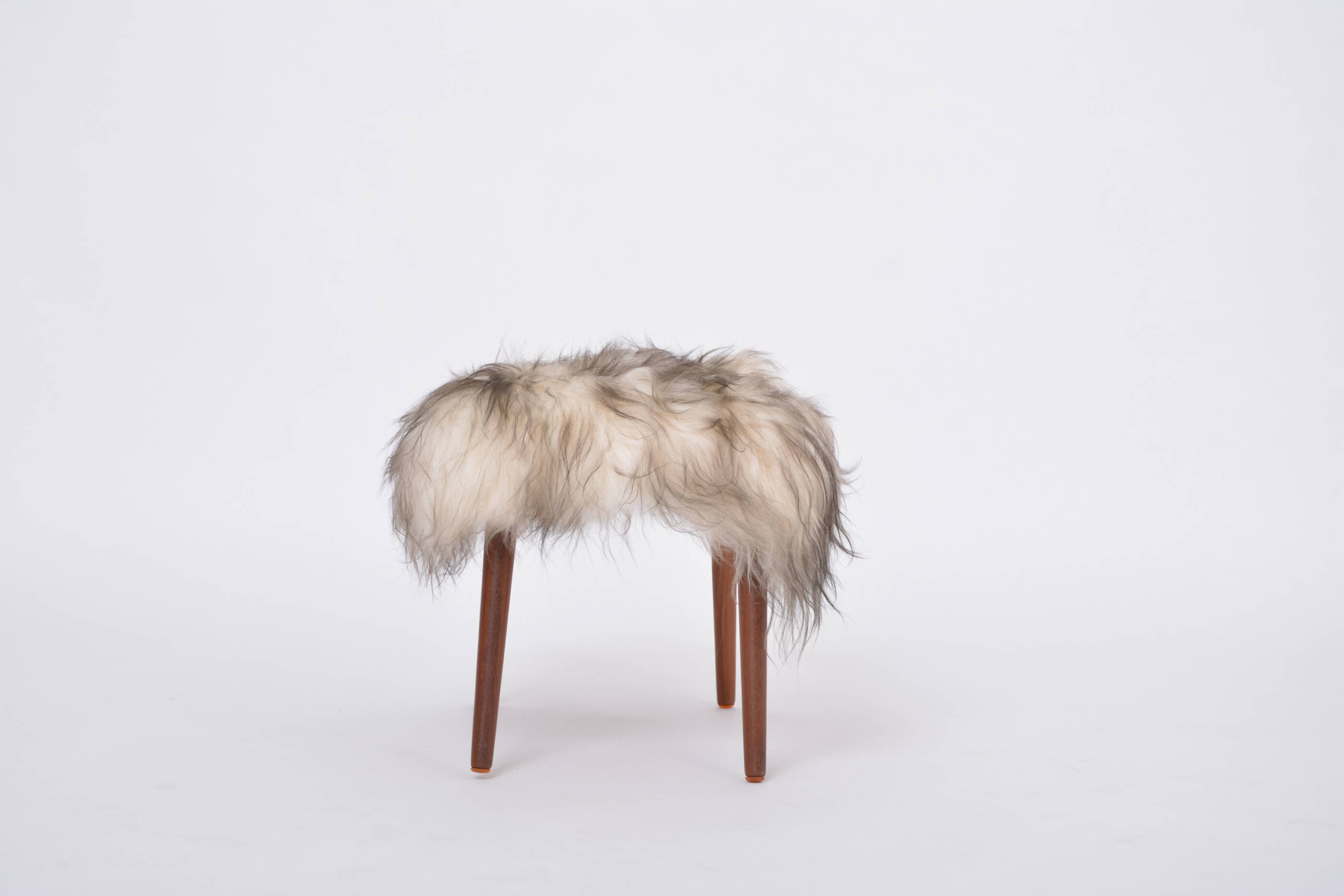 Danish Mid-century Modern stool reupholstered in white and black sheep skin