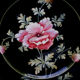 Old plate decorated with anemones or poppies on a black background