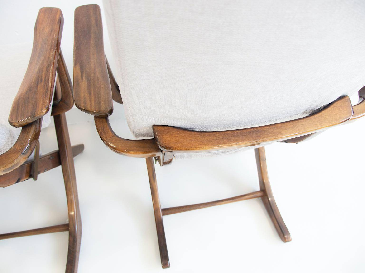 Pair of varnished wooden reclining armchairs, upholstered in lightweight fabric.