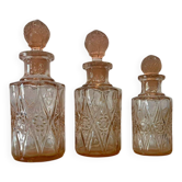 Set of 3 vintage pink glass bottles with corks.
