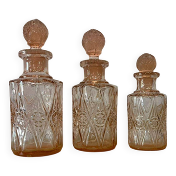 Set of 3 vintage pink glass bottles with corks.
