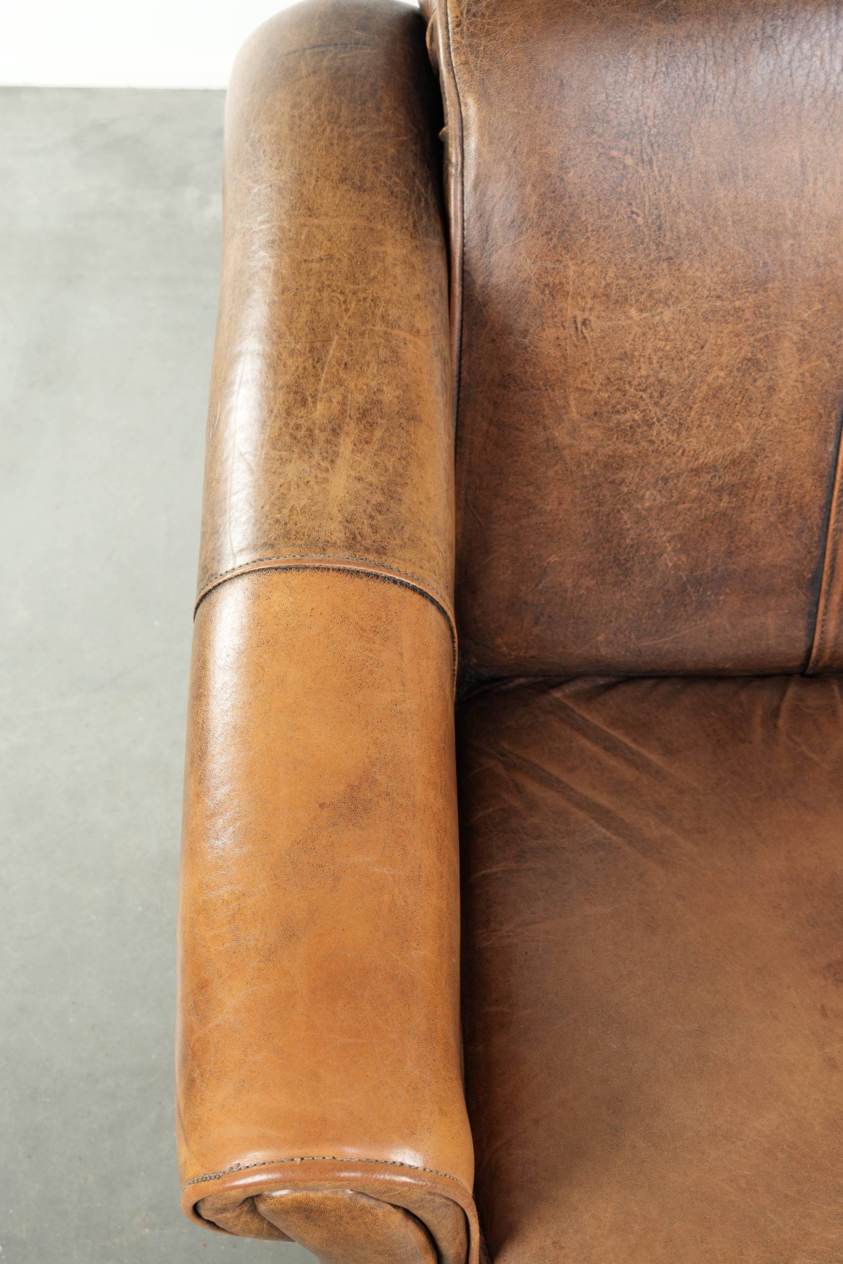 Fauteuil en peau de mouton magnifiquement conçu et confortable, avec un look intemporel et une finition de passepoil assortie.