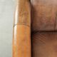 Fauteuil en peau de mouton magnifiquement conçu et confortable, avec un look intemporel et une finition de passepoil assortie.
