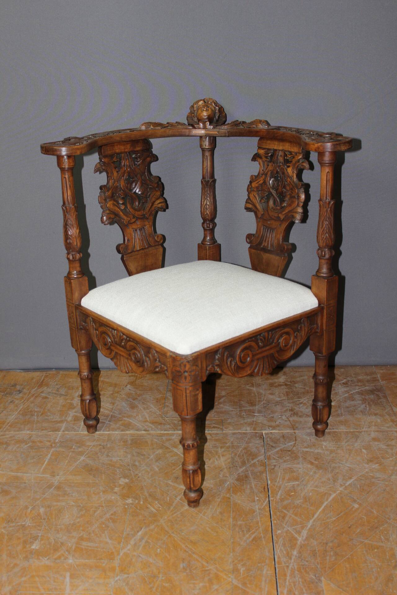 19th century walnut corner armchair with carved angel decoration