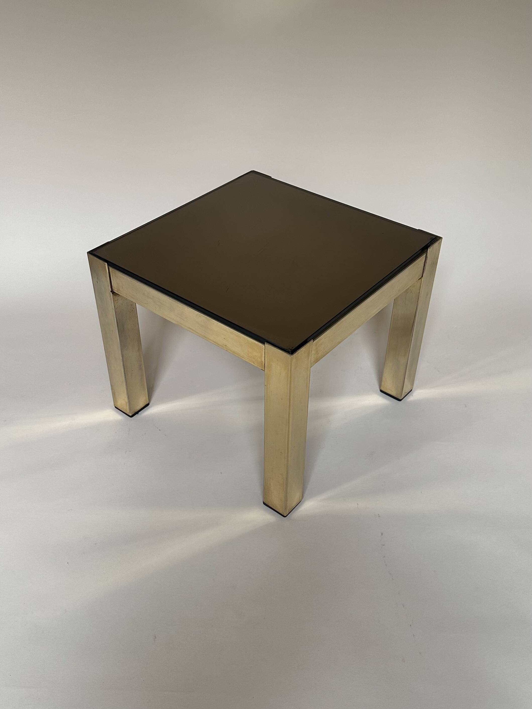Set of three nesting side tables in brass and smoked mirror.