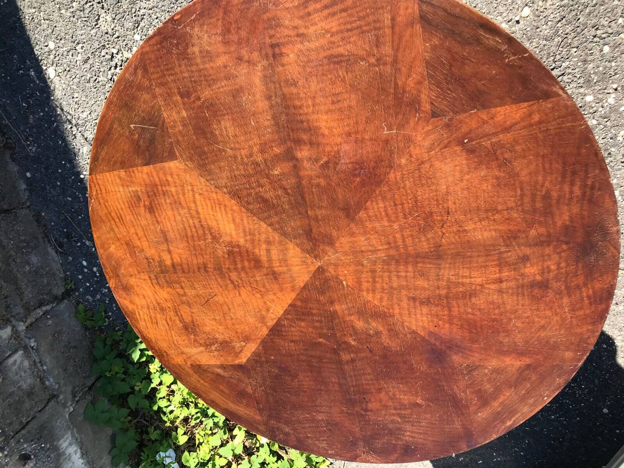Art Deco side table in brown walnut, round top and scroll legs, France 1930s.