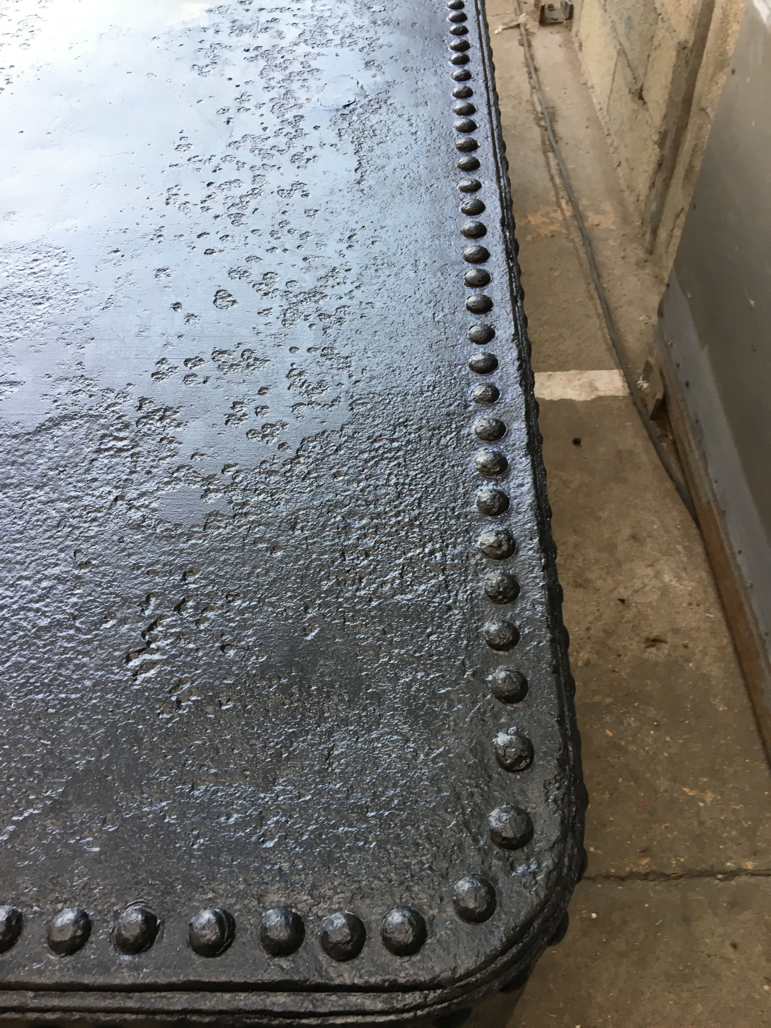 large industrial table in graphite black riveted metal