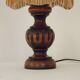 Mid-century French table lamp made of turned carved wood with a fringed shade.