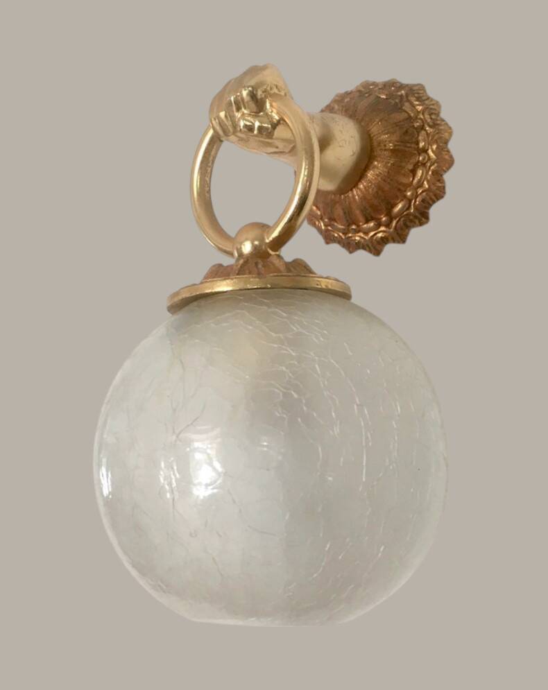 Wall light with golden hand and glass globe