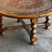 Vintage wooden turned coffee table with leather and astrological decoration.