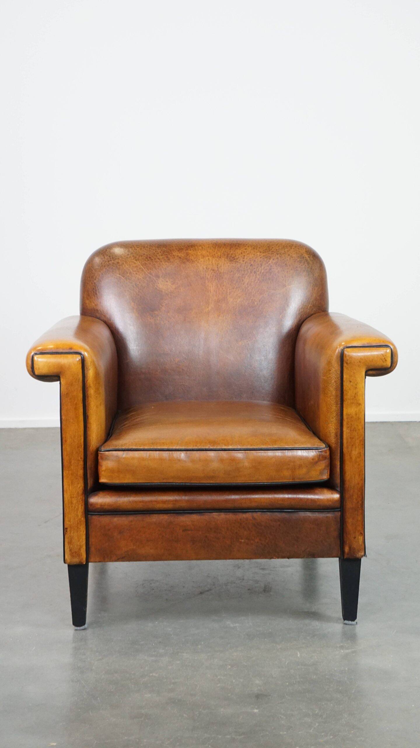 Sheepskin Art Deco design armchair with sleek finish and black piping