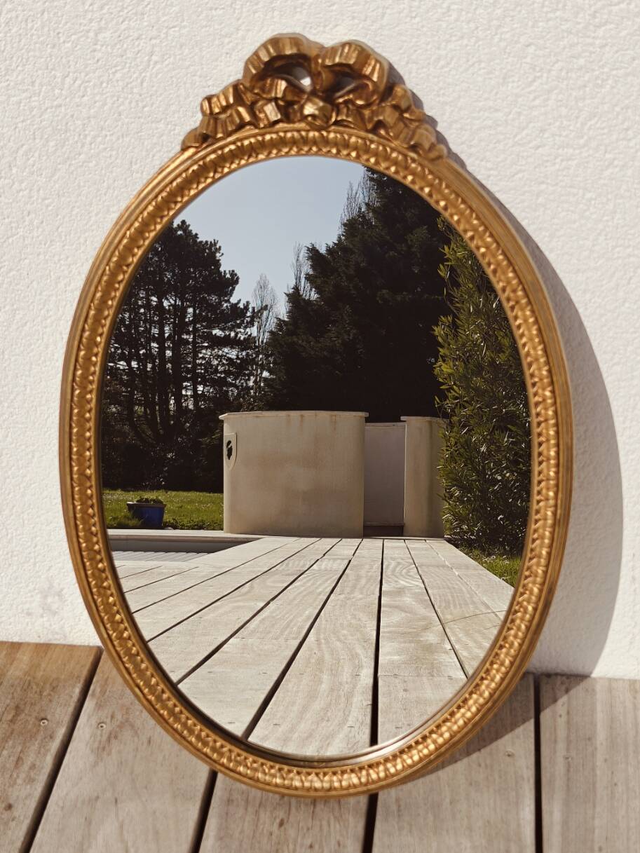 Authentic chic vintage oval mirror, in gilded wood, in baroque style.