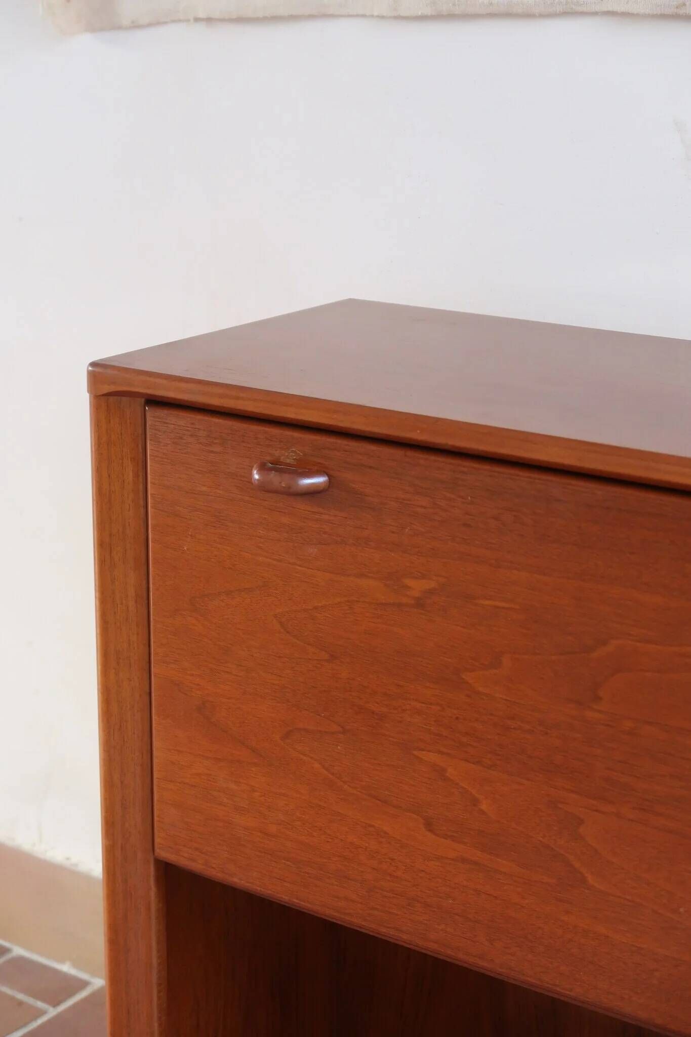 Vintage teak bar cabinet with black glass interior.
