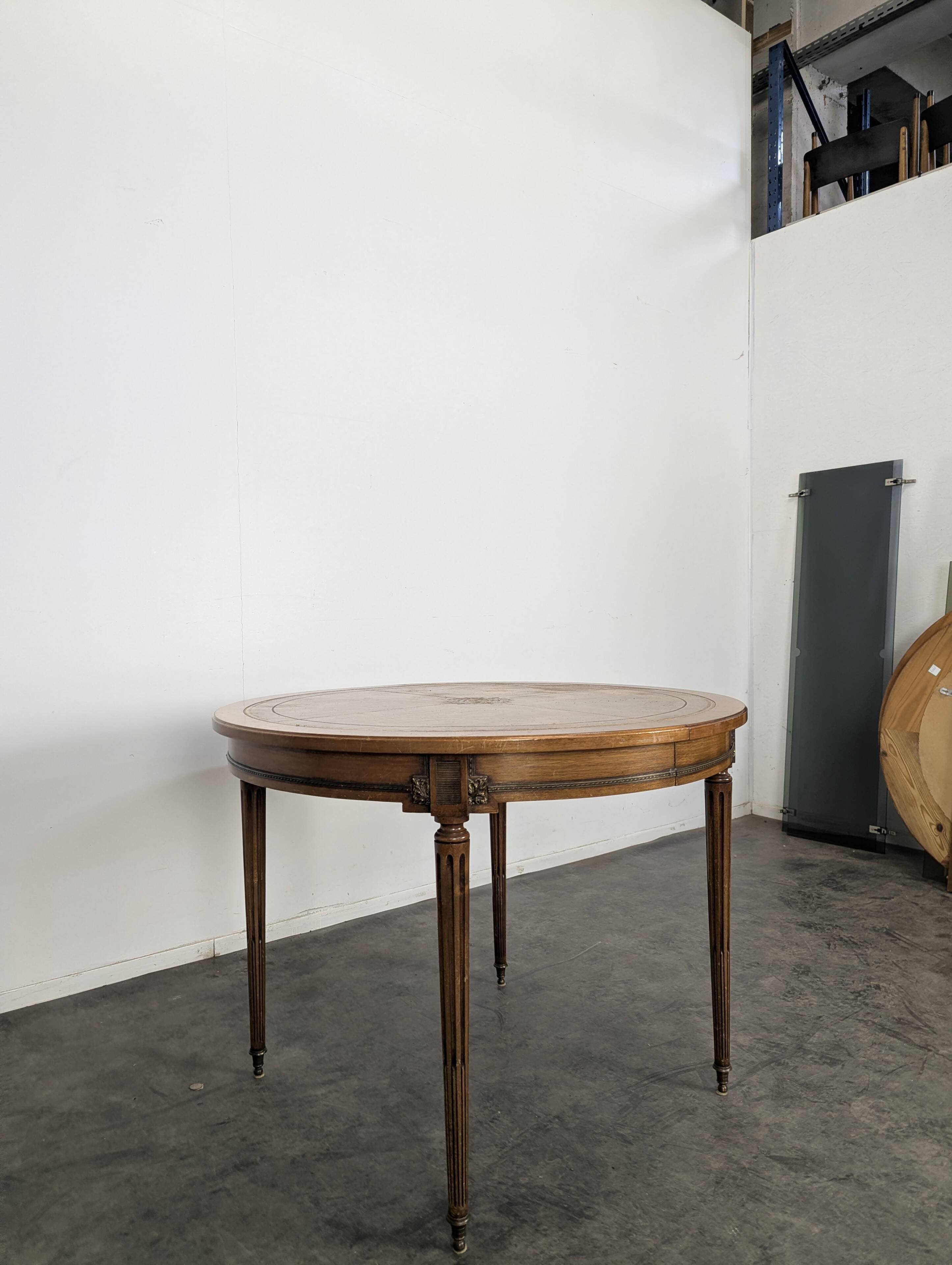 Louis XVI style dining table with a leather top.