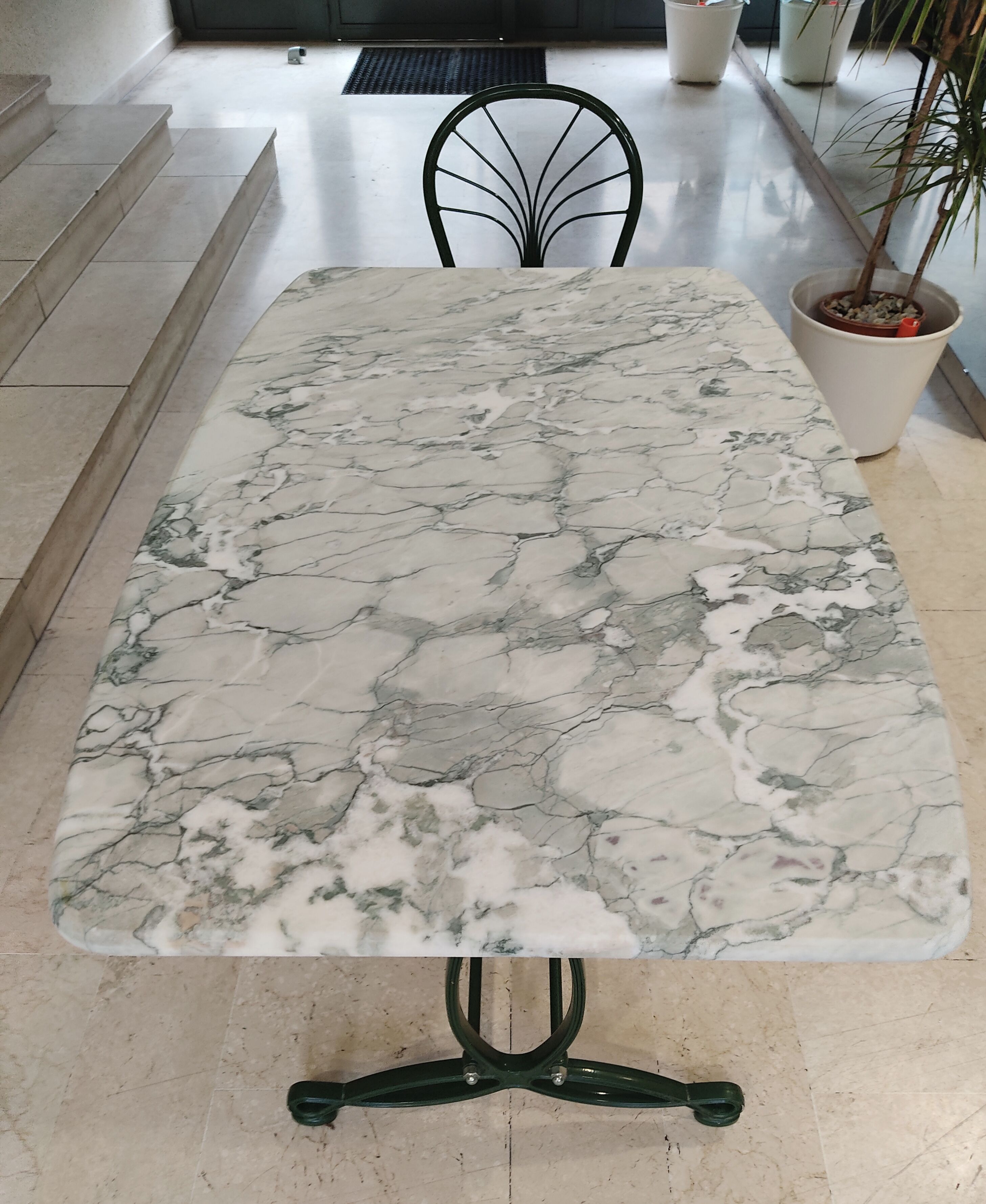 Table à manger en marbre, pieds fonte verts et 4 chaises tube acier assorties revêtement simili cuir