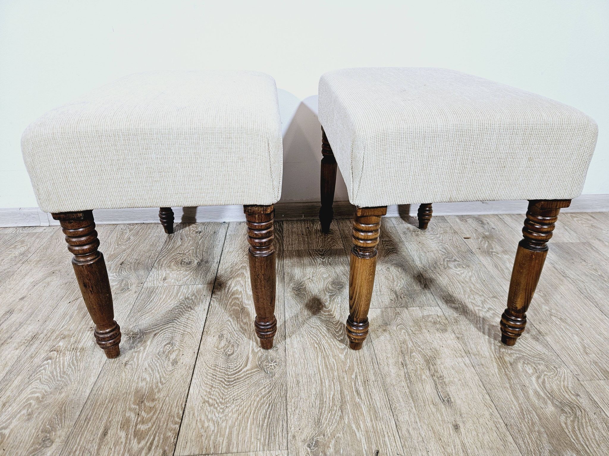 A pair of English upholstered pouffes/footstools from the 19th century