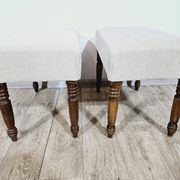 A pair of English upholstered pouffes/footstools from the 19th century
