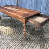 Antique farmhouse table in solid cherry wood with turned legs.