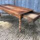 Antique farmhouse table in solid cherry wood with turned legs.