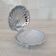 Shell-shaped butter dish in stainless steel and white glass bowl.