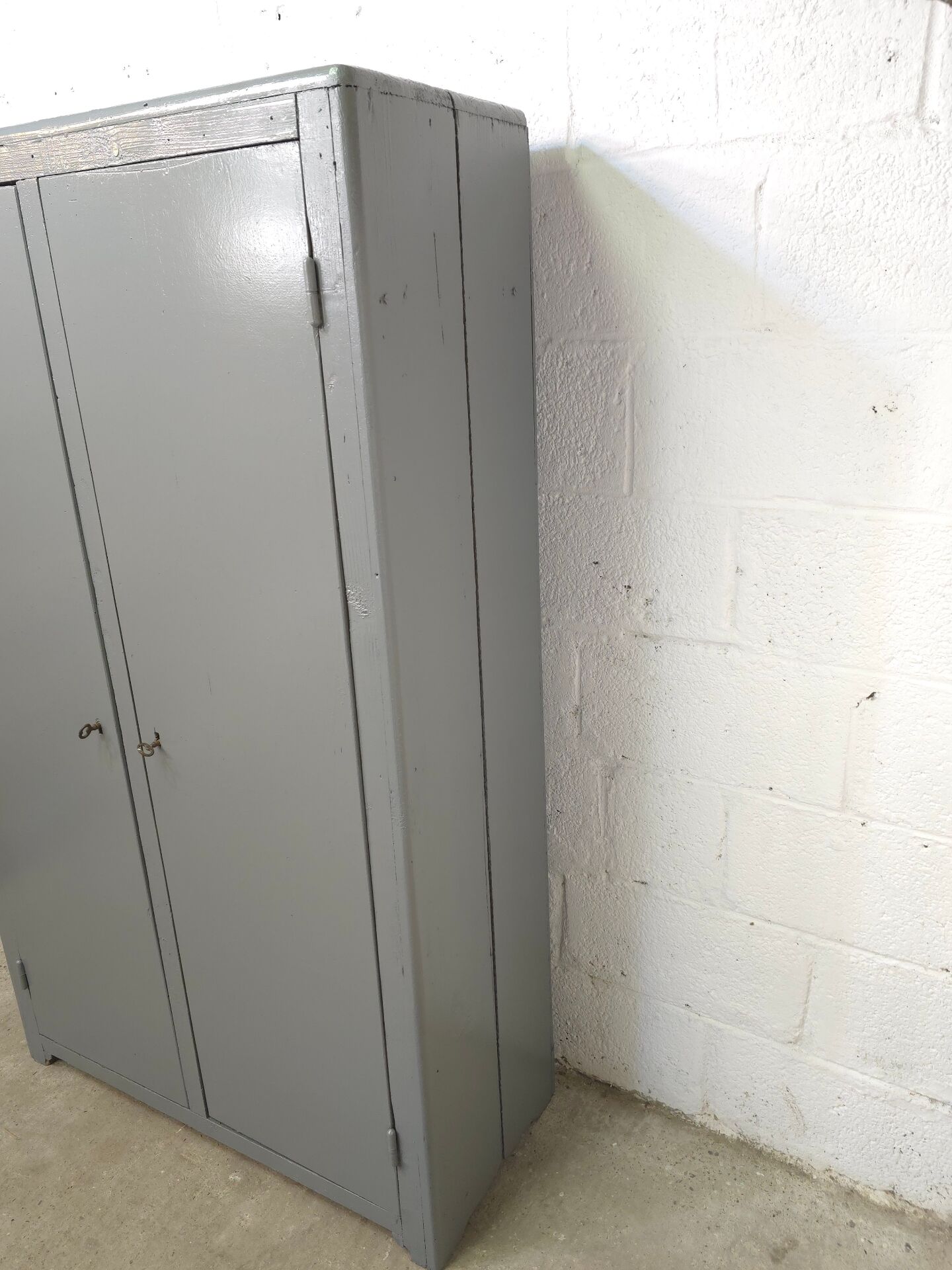 Curved wardrobe workshop locker made of wood repainted in grey.