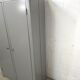 Curved wardrobe workshop locker made of wood repainted in grey.