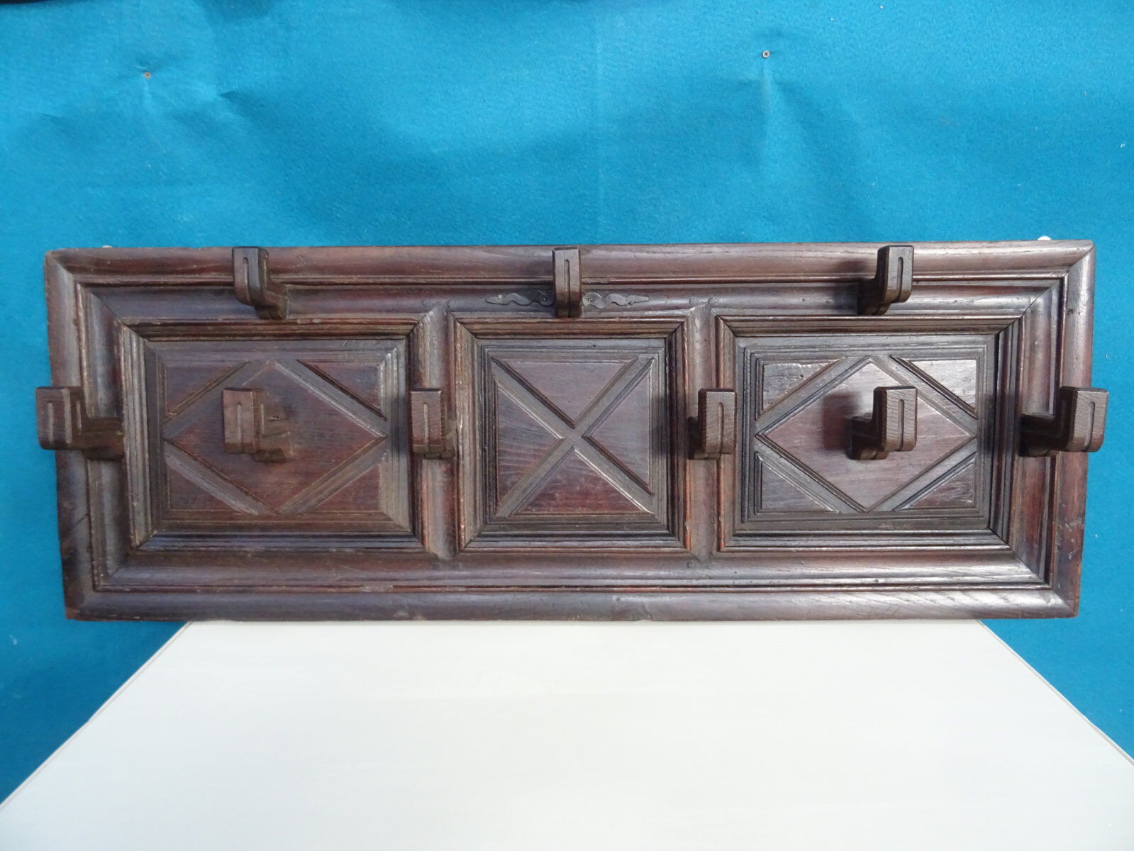 Wall-mounted coat rack in solid oak with 9 hooks.