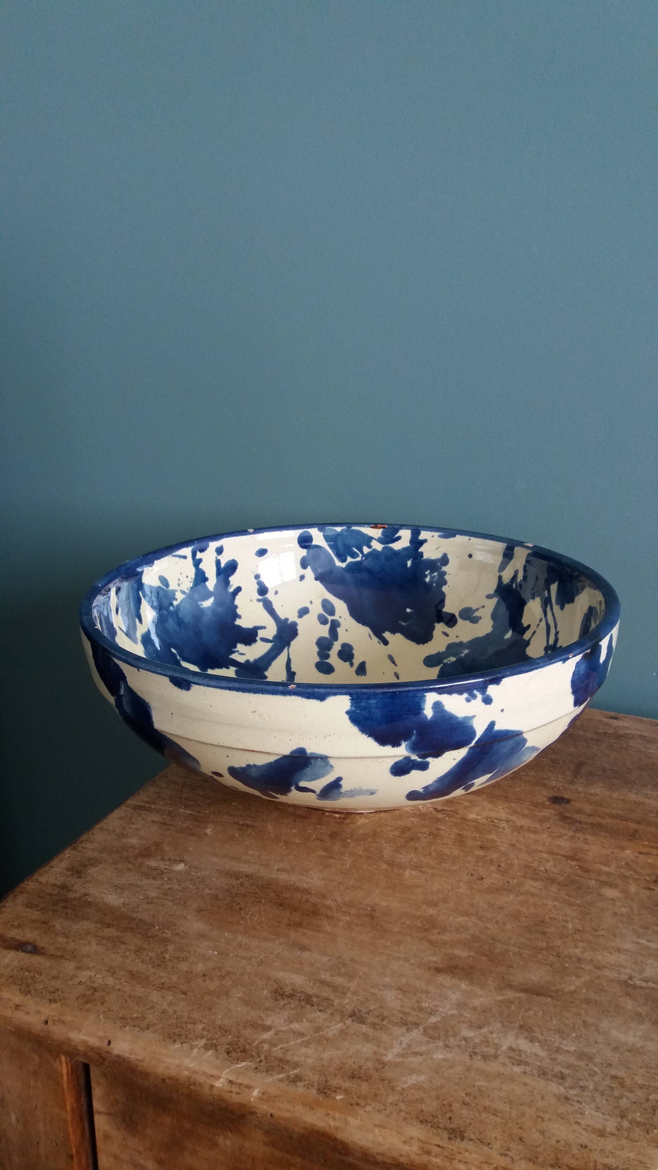 Empty pocket bowl in terracotta, glazed with "ink spots" design.