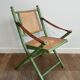 Paire de chaises safari pliantes façon faux-bambou patiné, dossiers et assises cannées et repose-bras en cuir