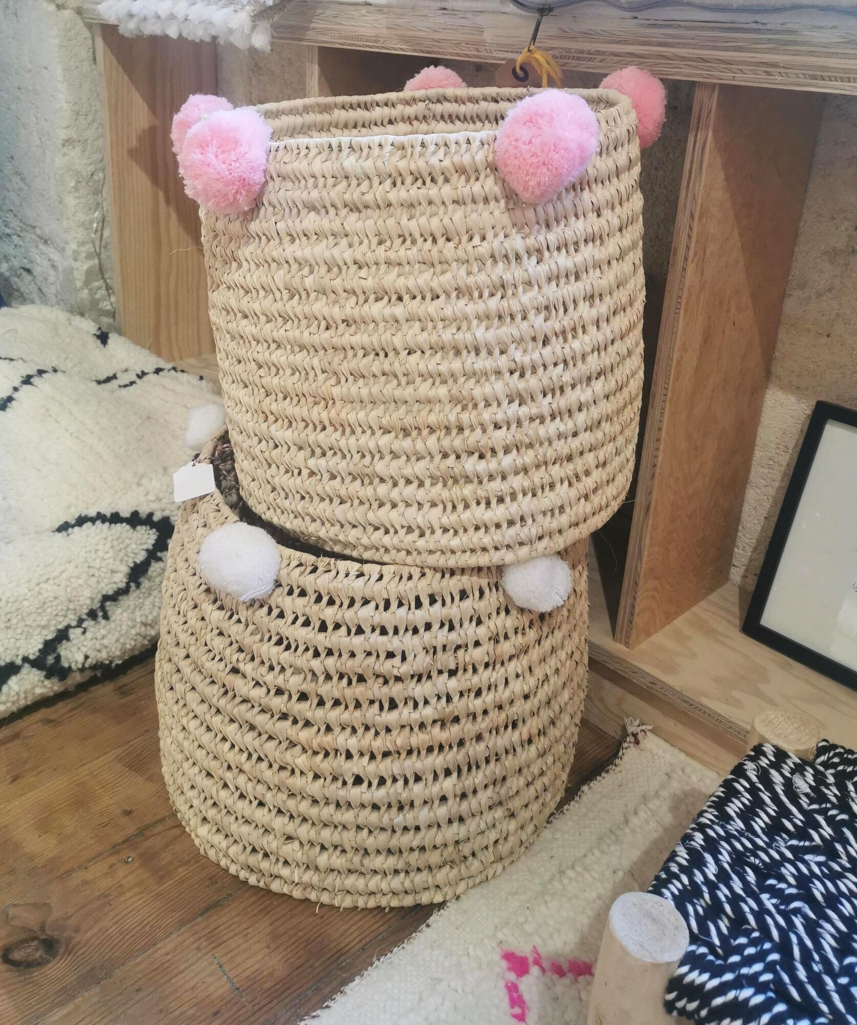 Moroccan basket with pale pink pompoms made of palm fiber
