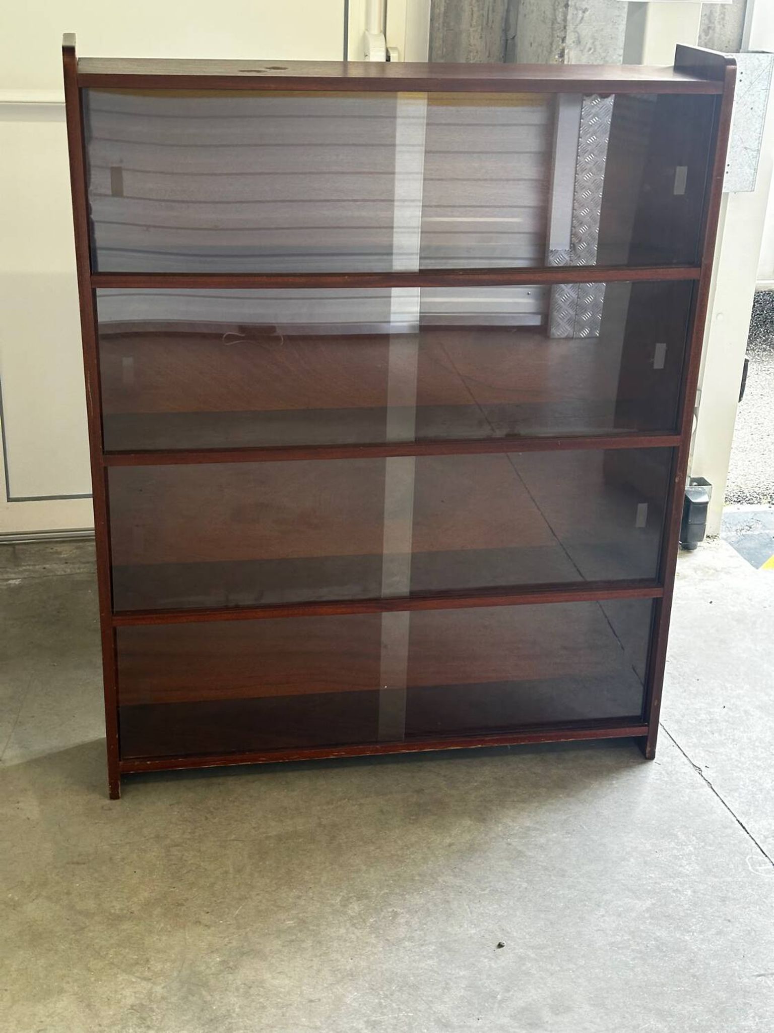 Vintage 1960s wooden library with sliding doors.