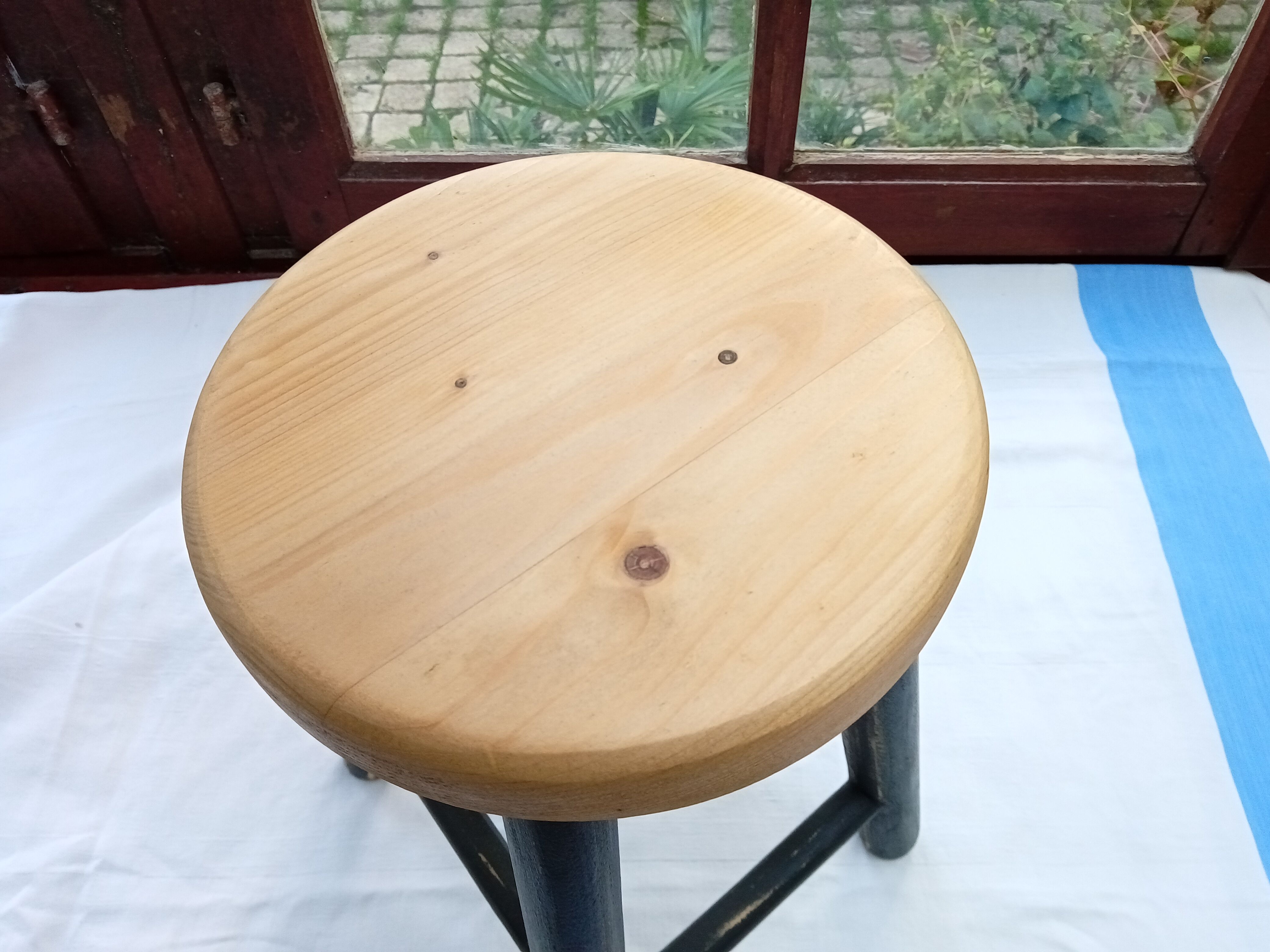 Low wooden stool and black patina