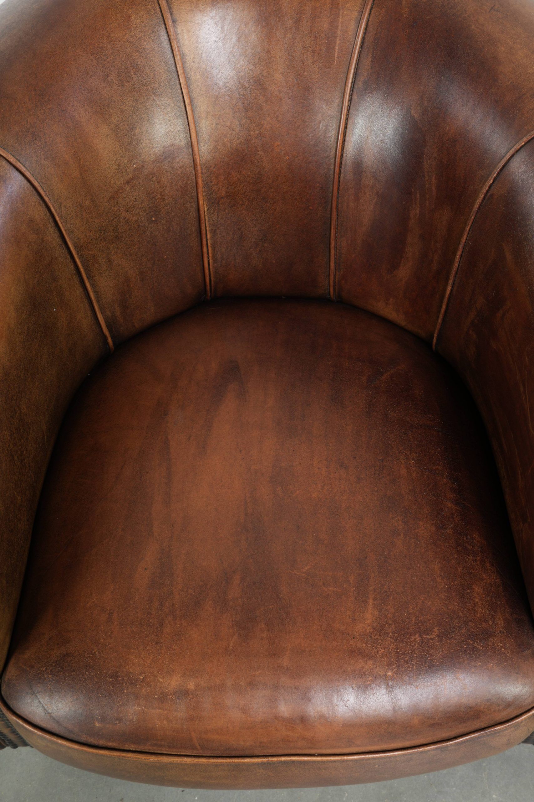 Sheepskin clubarmchair with beautiful patina finished with decorative nails