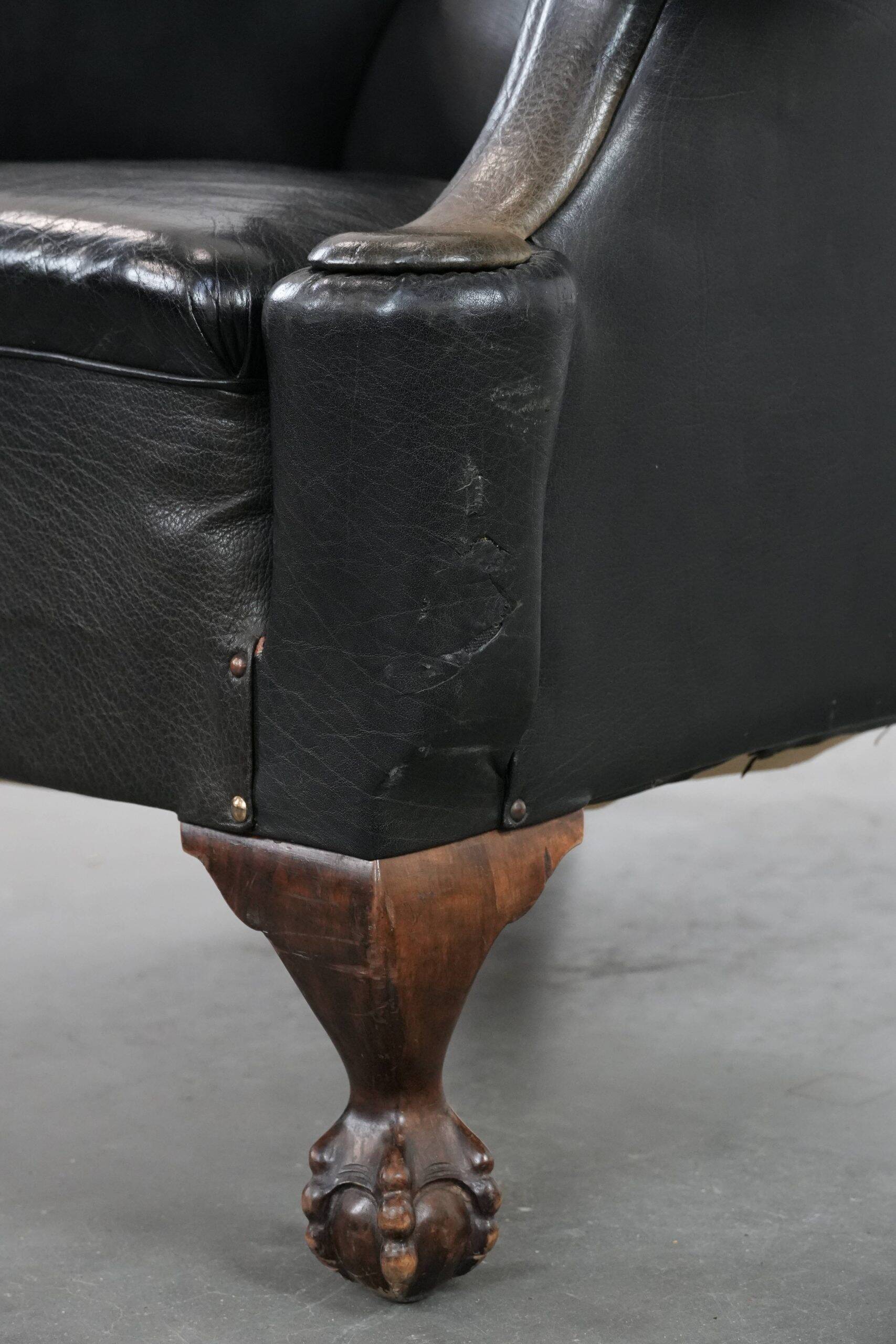 Antique black English cow leather wingback armchair from the 19th century