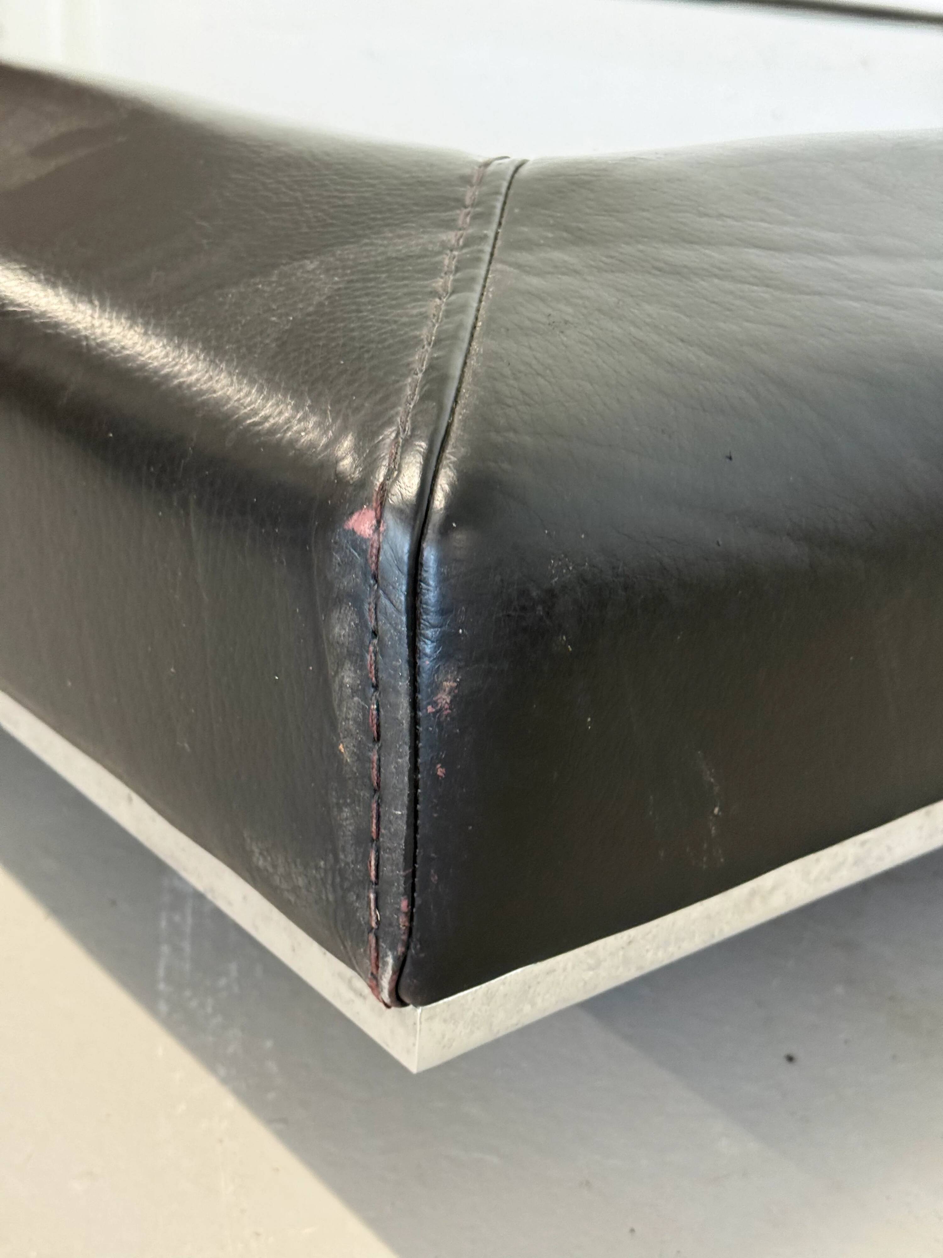 Vintage coffee table covered in leather, smoked mirror top and chrome legs.