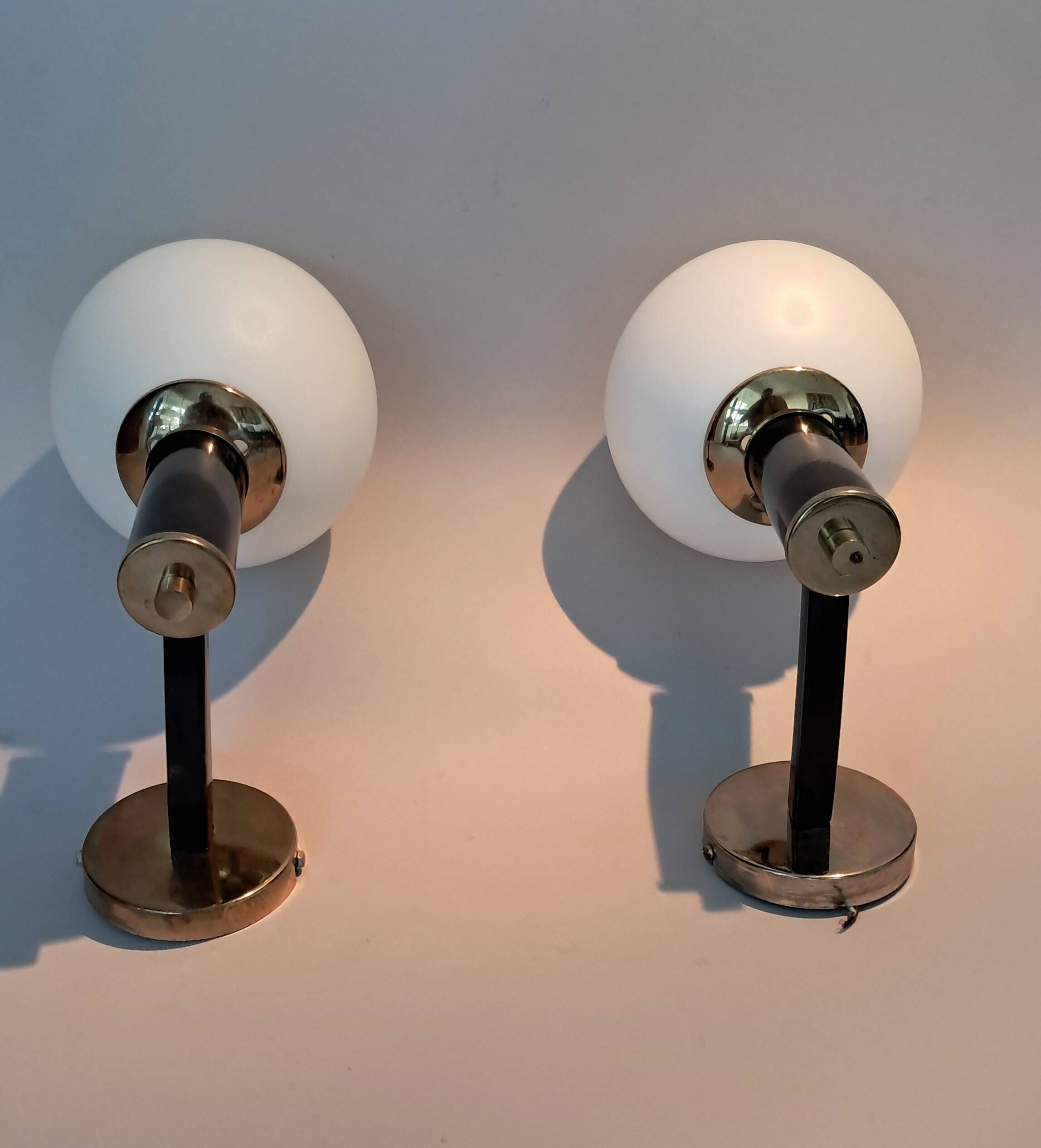 Pair of wall lights in gilded and black lacquered brass, Italy 1970/1980.