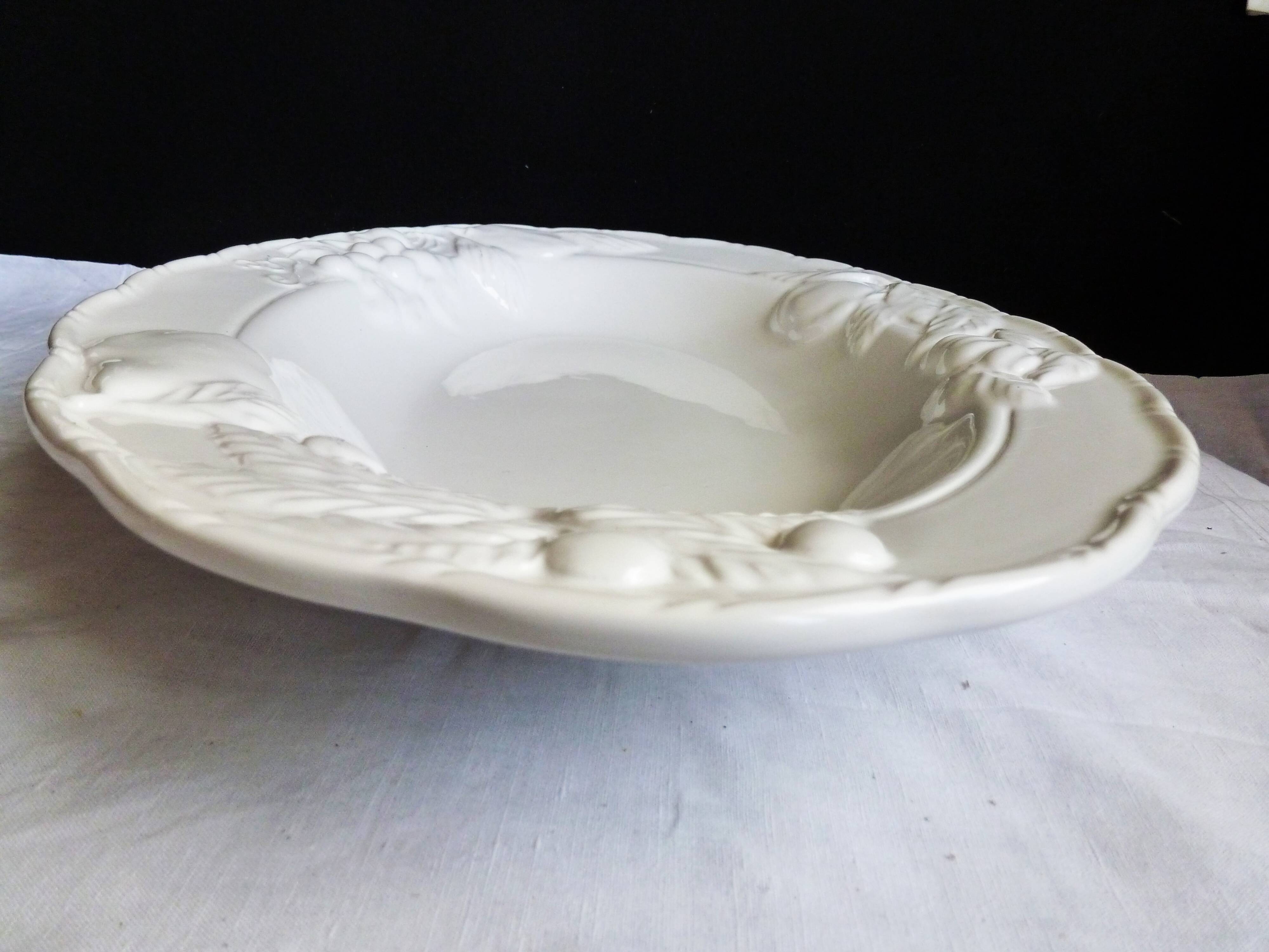 Oval white vegetable dish, an antique tableware piece in barbotine earthenware.