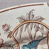 Large antique plate stamped with a fauna and flora pattern.