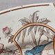 Large antique plate stamped with a fauna and flora pattern.
