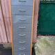 Scandinavian shoe storage cabinet in grey wood and metal.