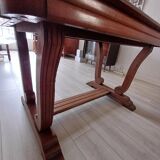 Solid wood dining table with a sculptural base.