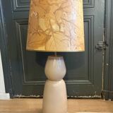 Large beige ceramic table lamp with a vintage shade.