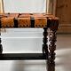 Antique turned wooden stool with woven leather.