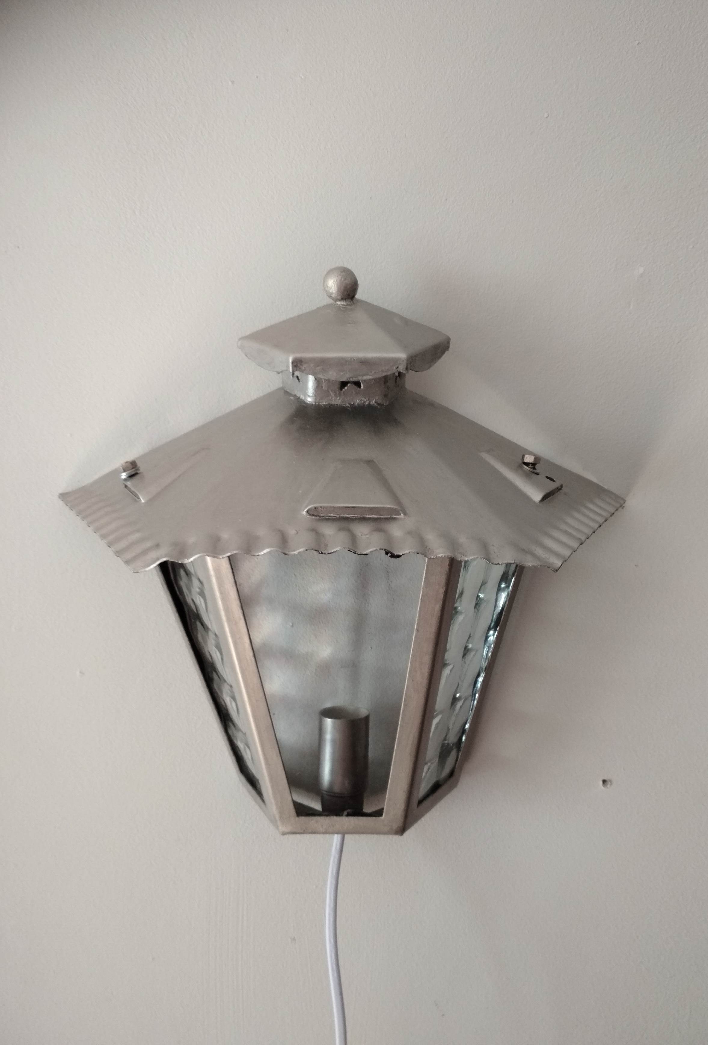 Half grey metal wall sconce and 3 windows